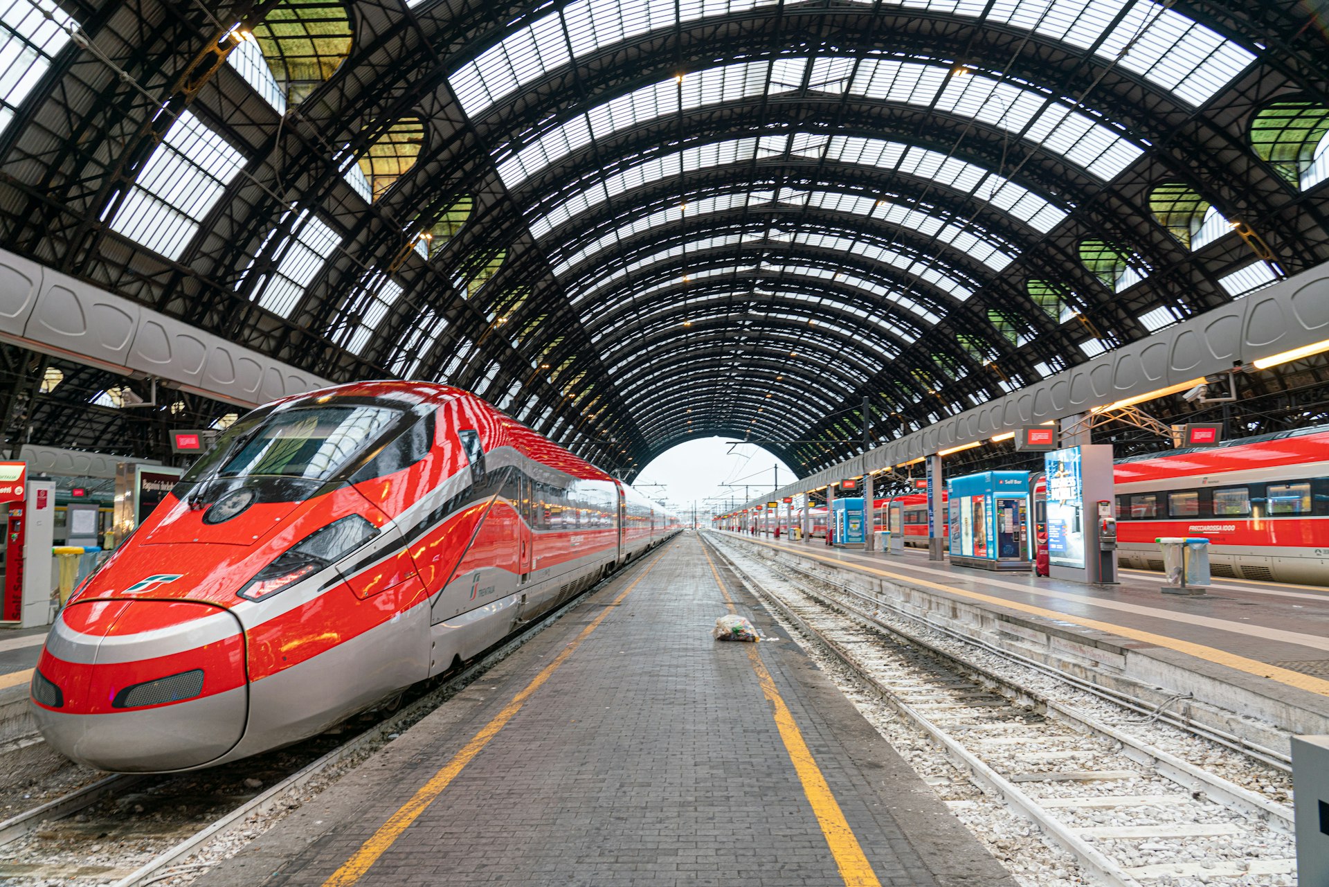 a red and silver train is at a train station